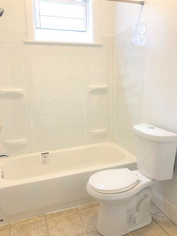a white bathroom with a toilet and a tub