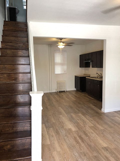 an empty living room with wood floors and a staircase