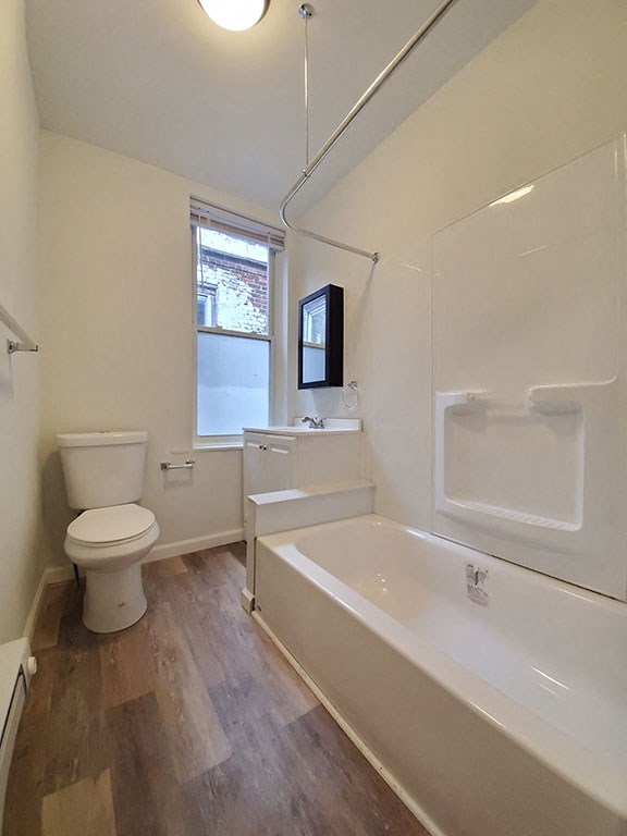 a bathroom with a toilet and a tub and a sink