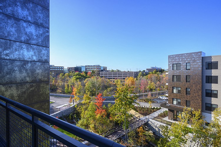 a view of the city from a balcony with trees and buildings