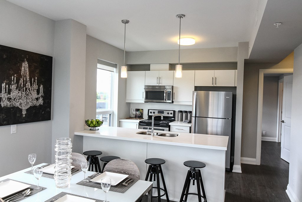 a kitchen with a bar and stools and a dining table