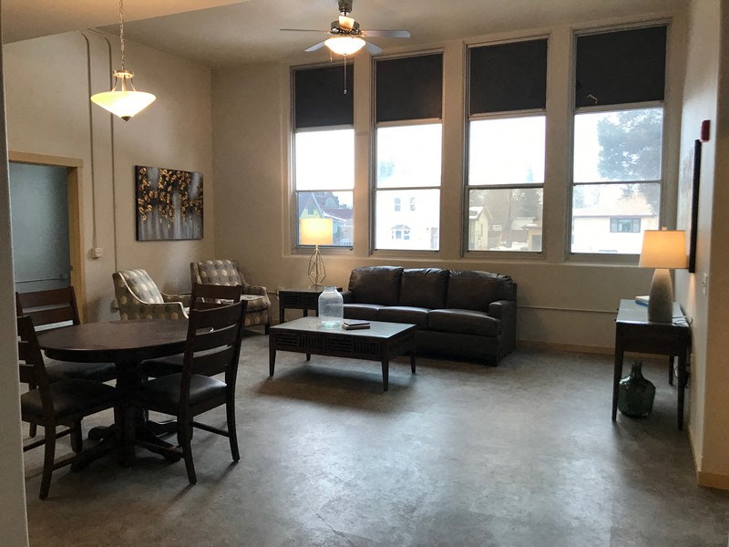 an empty living room with a table and chairs