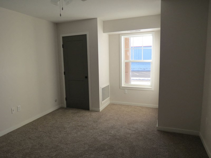 an empty room with a window and a door