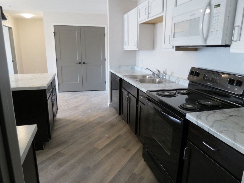 a kitchen with black appliances and white cabinets