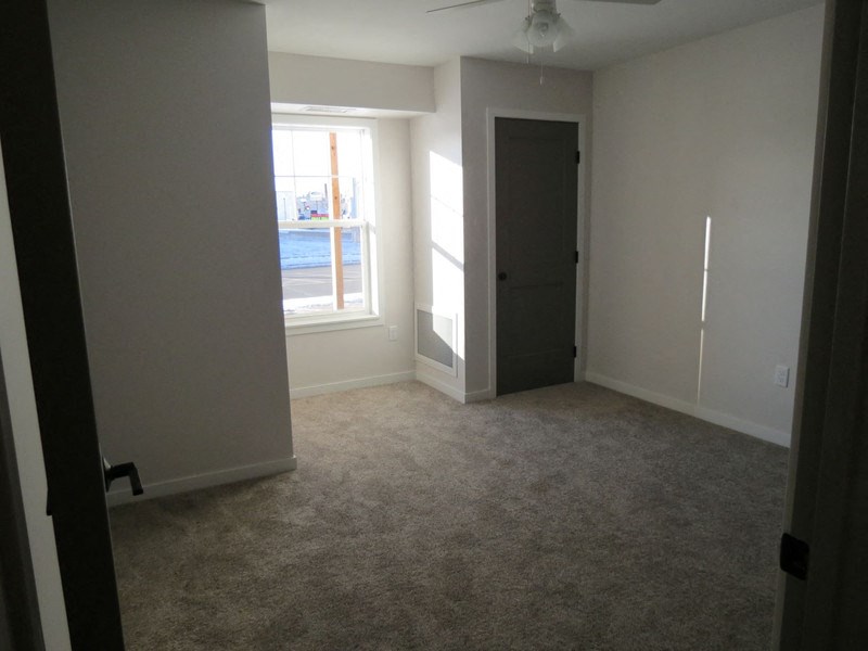 an empty living room with a window and a door