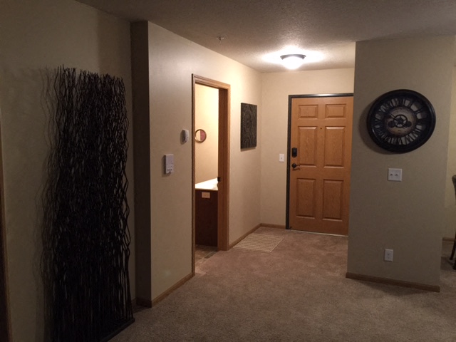a hallway with a door to a bathroom and a closet