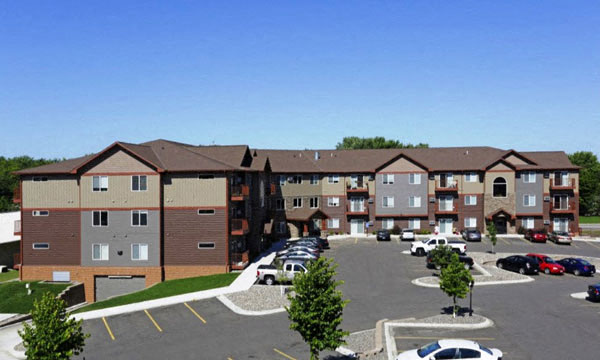 an aerial view of an apartment complex with a parking lot