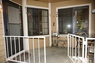 a porch with a white railing and two windows