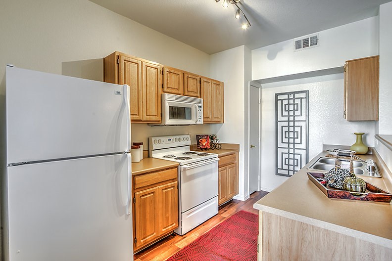 a kitchen with white appliances and wooden cabinets