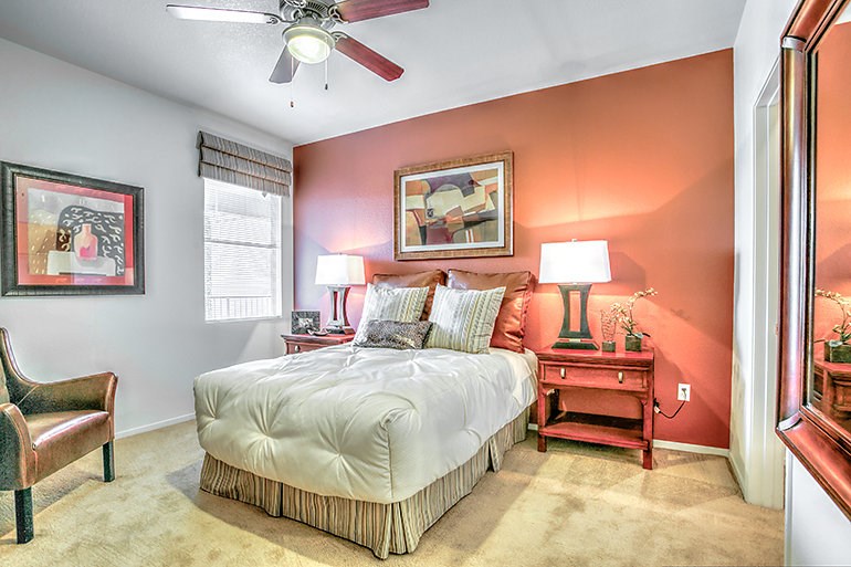 a bedroom with a bed and a ceiling fan
