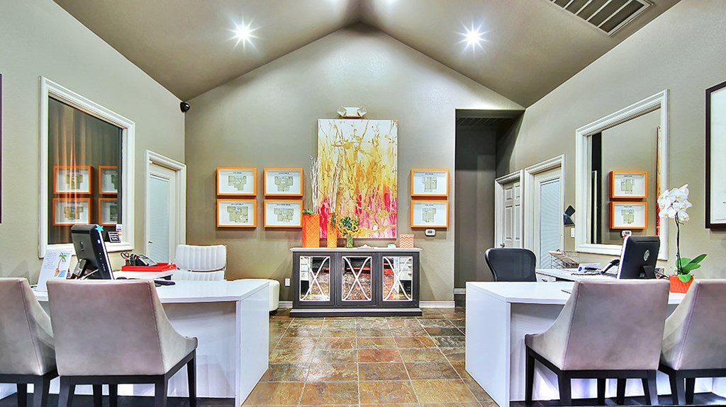 a home office with two tables and chairs and a painting on the wall
