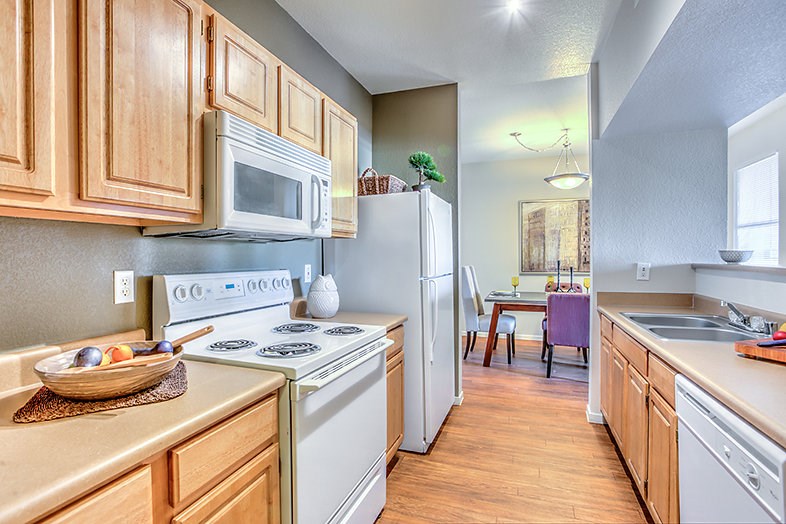 a kitchen with white appliances and wooden cabinets