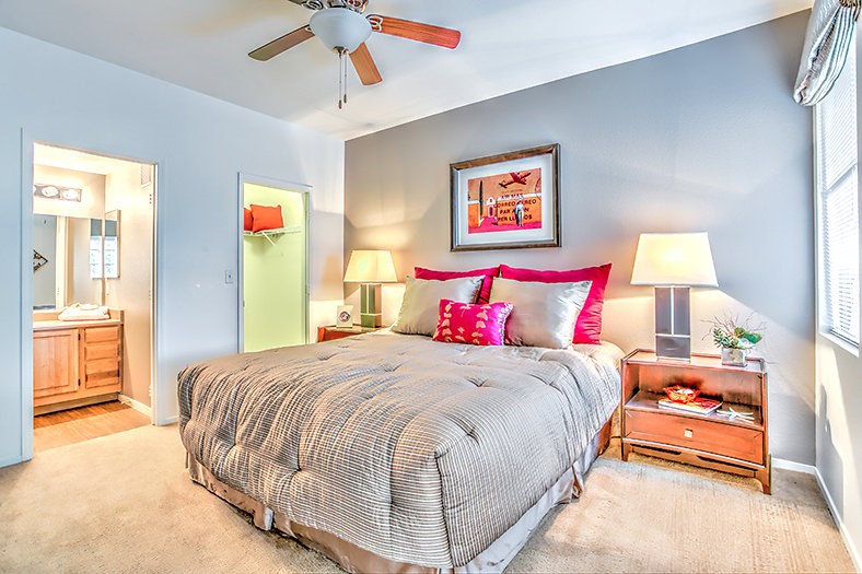 a bedroom with a bed and a ceiling fan