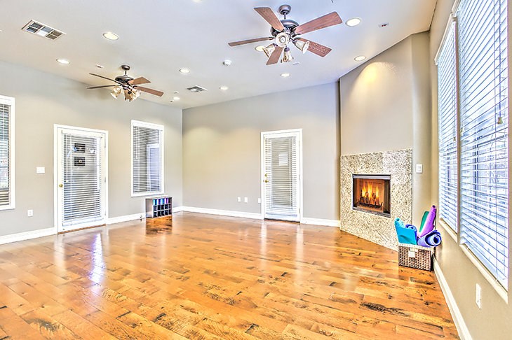 an empty living room with a fireplace and wooden floors