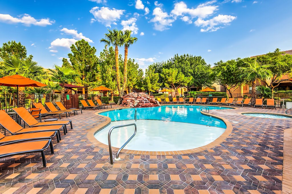 a swimming pool with chairs and umbrellas at the resort