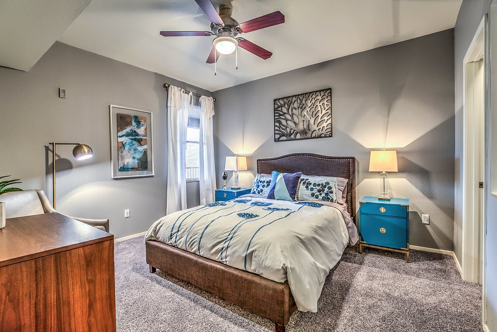a bedroom with a bed and a ceiling fan