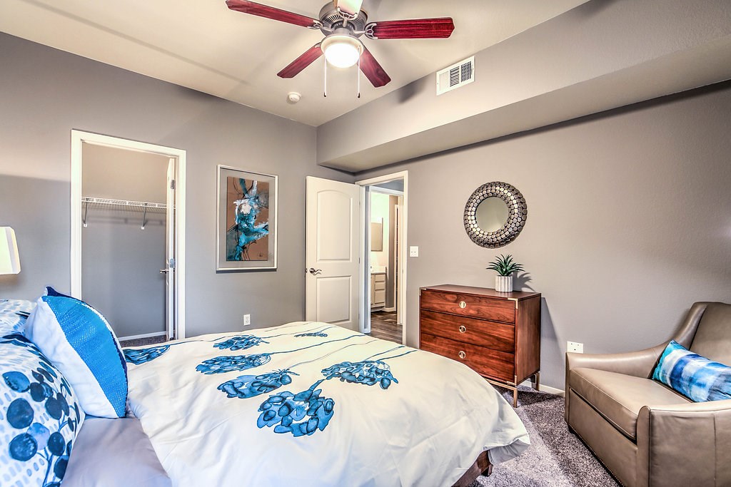 a bedroom with a large bed and a ceiling fan