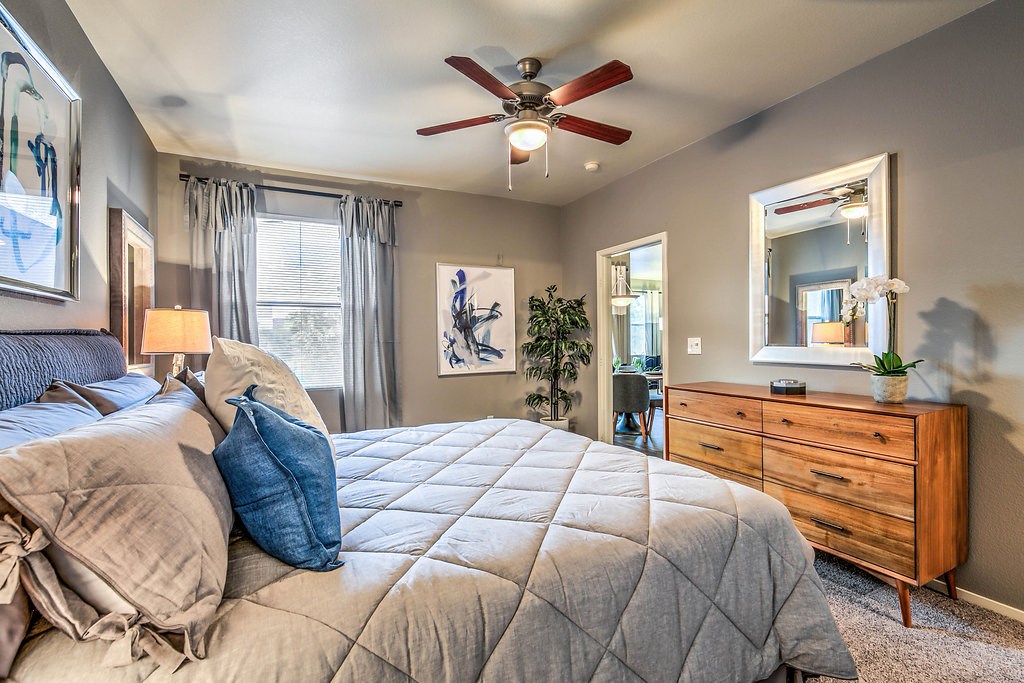 a bedroom with a large bed and a ceiling fan