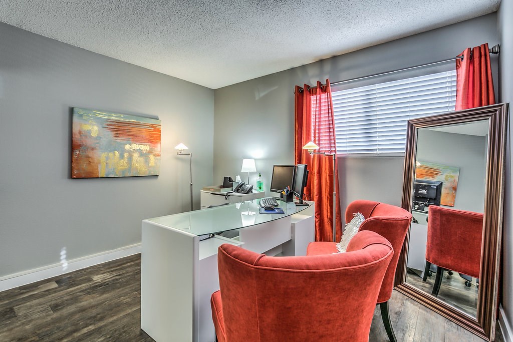 a living room with two chairs and a desk with a mirror