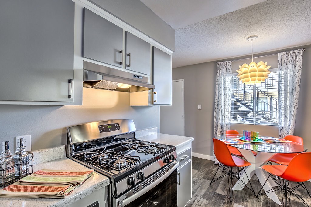 a kitchen with a stove and a table with chairs