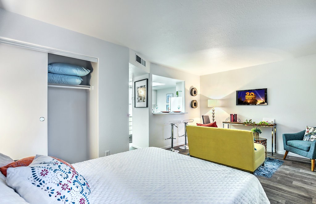 a bedroom with a bed and a living room with a couch