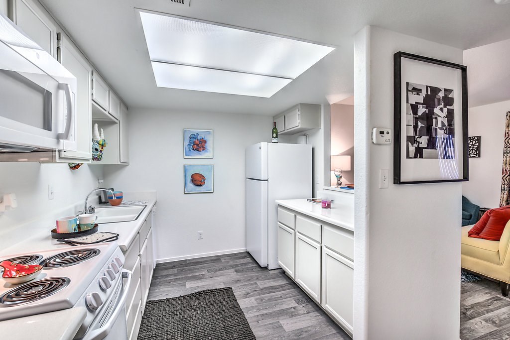 a white kitchen with a stove and a refrigerator
