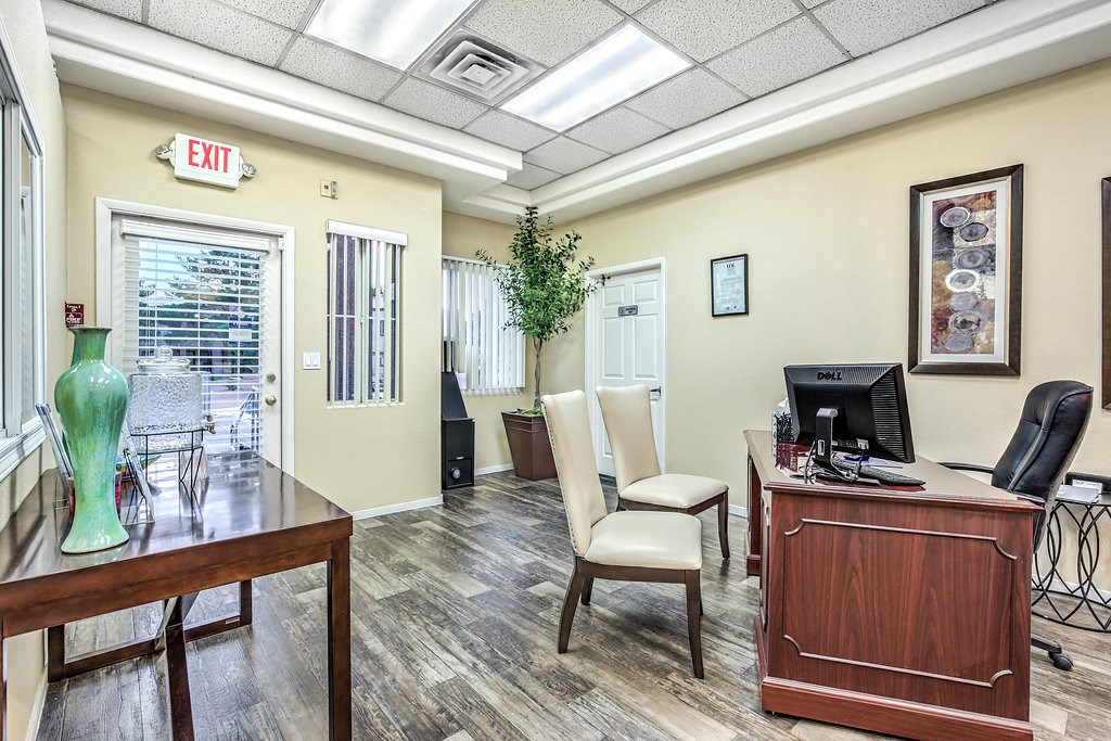 a office with a desk and a computer and a window