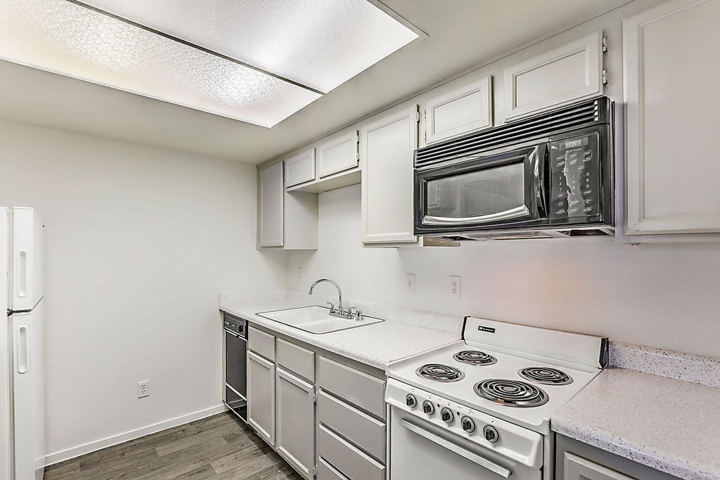 a kitchen with white appliances and a microwave