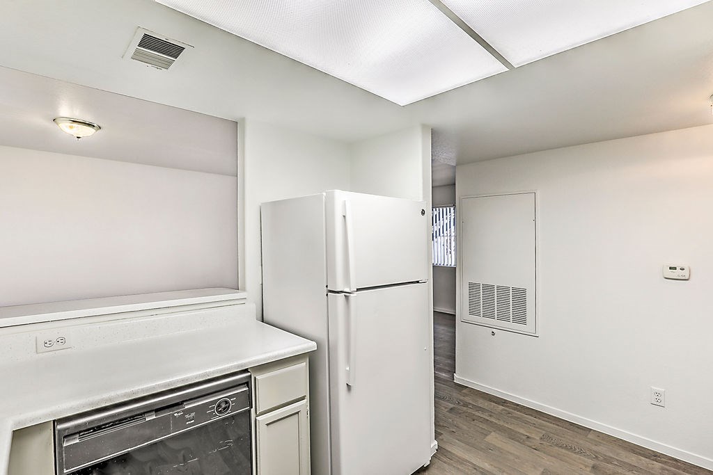 an empty kitchen with a refrigerator and a washer and dryer