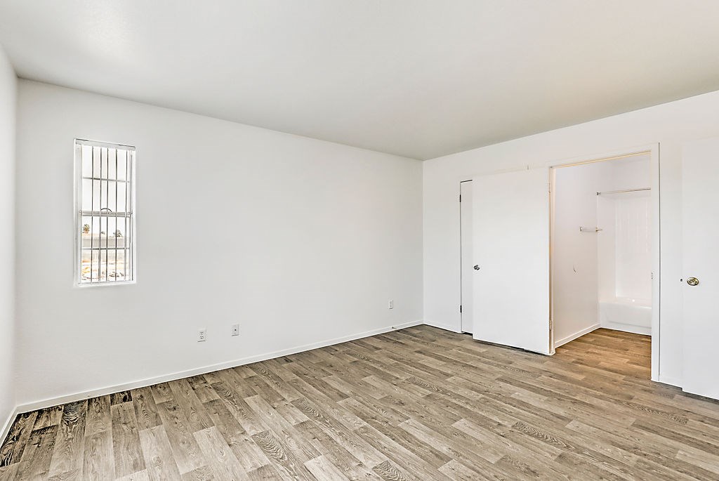 an empty living room with wood flooring and white walls