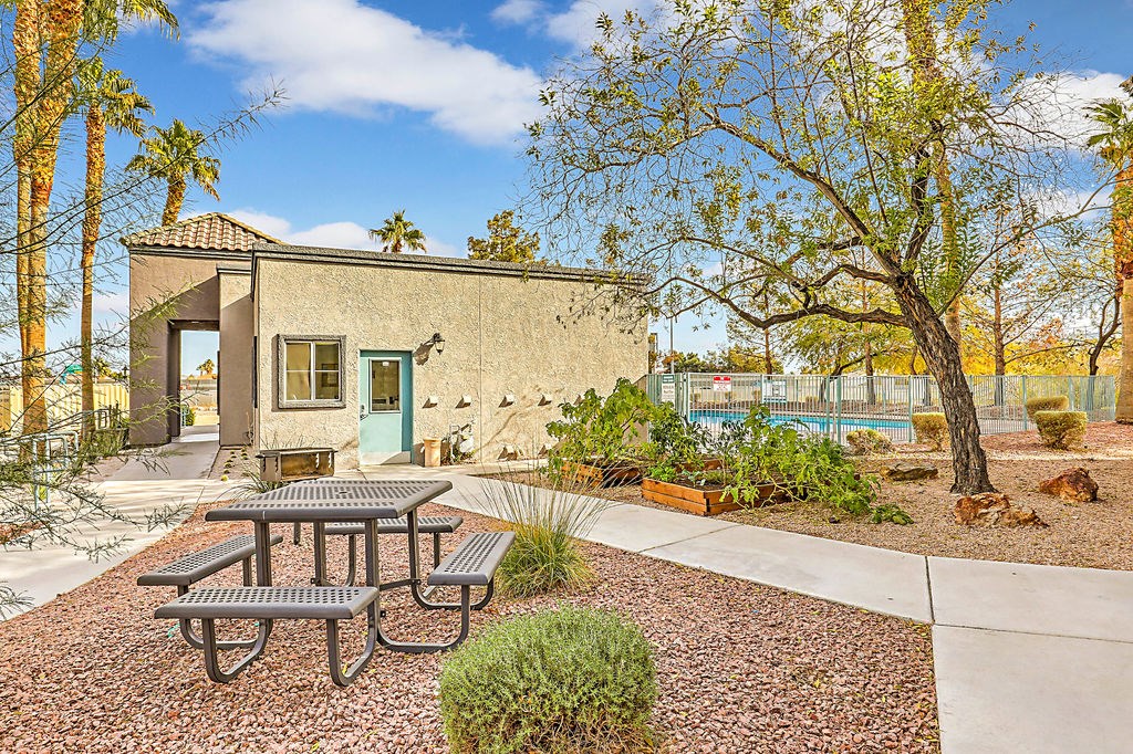 a picnic table in front of a building with a pool