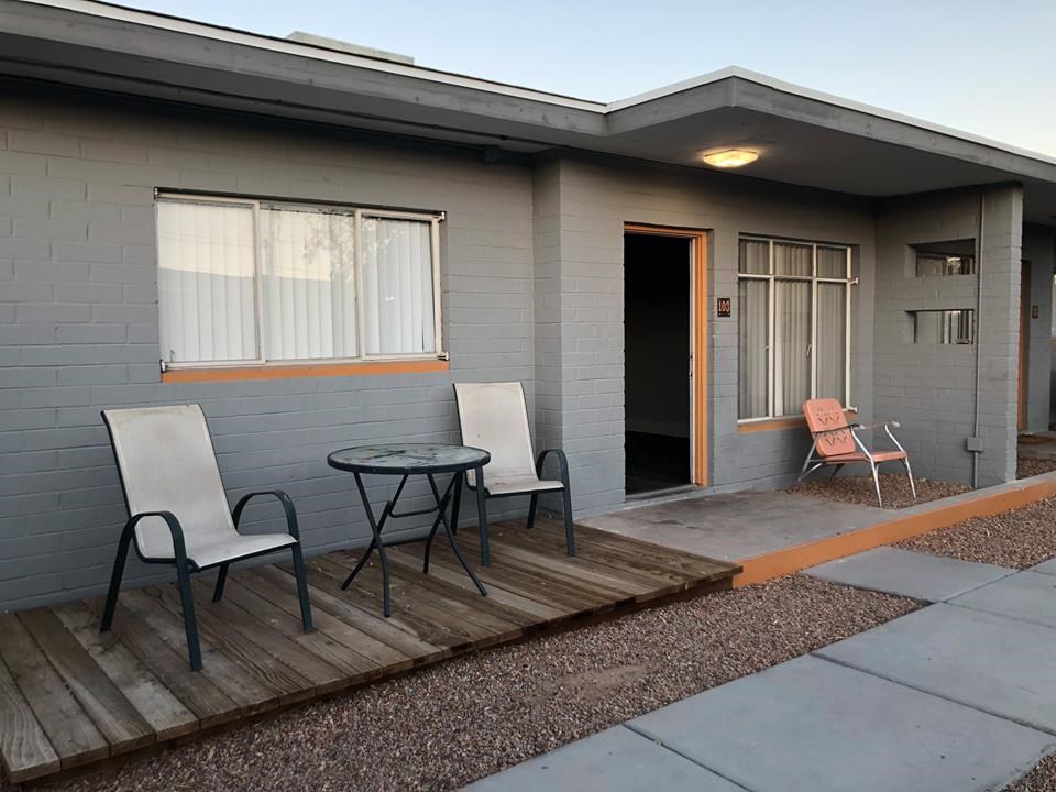 a patio with chairs and a table in front of a house