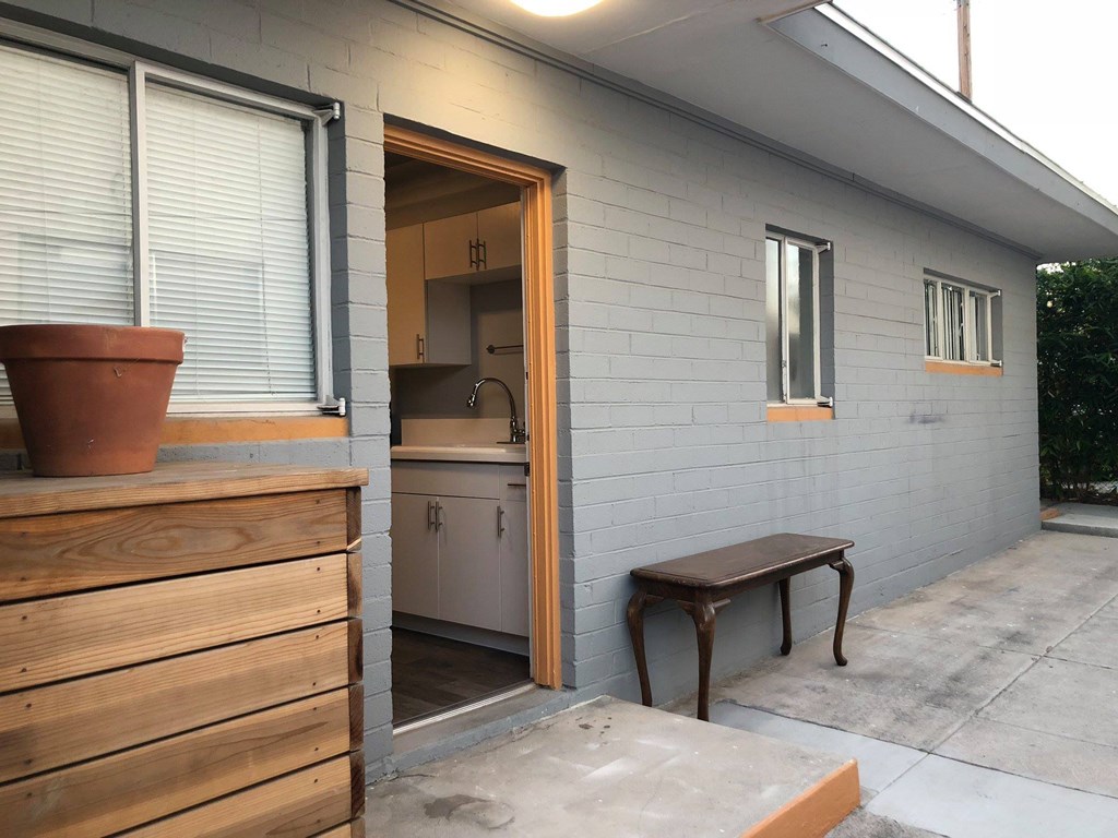 a small porch with a door to a kitchen and a bench