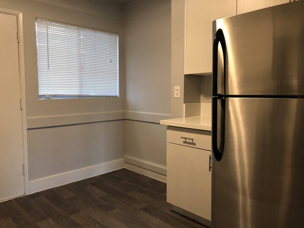a kitchen with a stainless steel refrigerator and a window