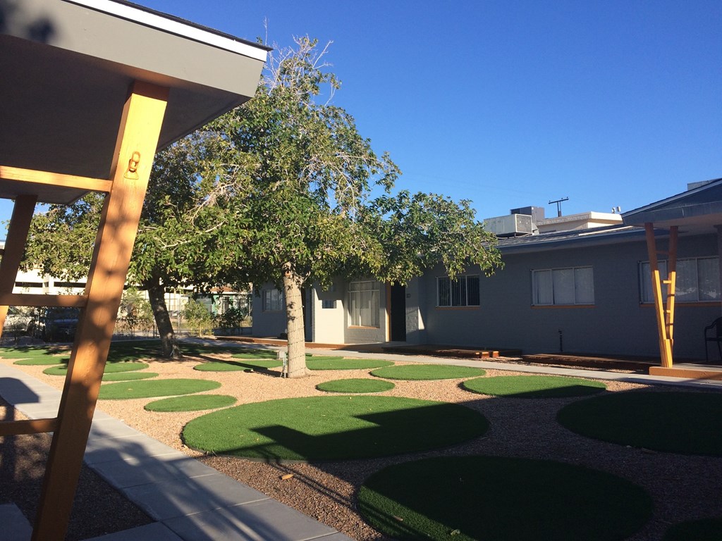 a yard with grass and trees in front of a house