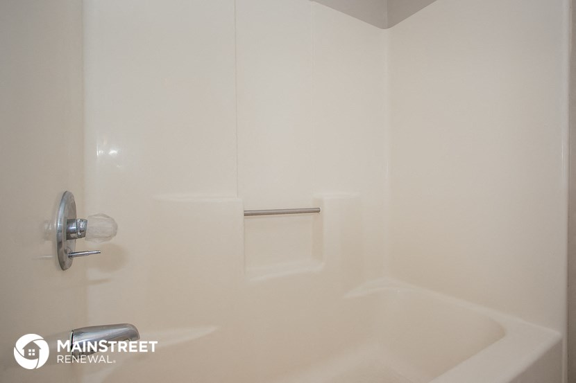 a white bathroom with a shower and a sink