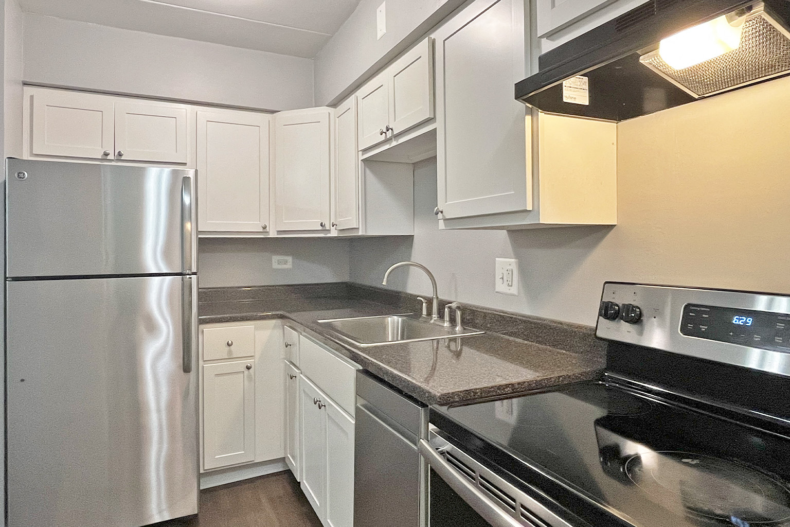 A kitchen with a stainless steel refrigerator and oven.