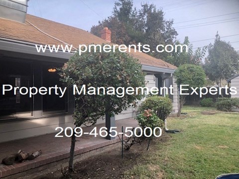 A house with a sign that says Property Management Experts.