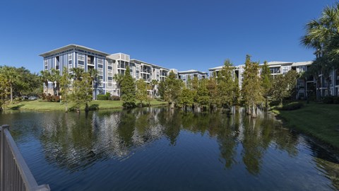 a building overlooking a lake with trees in front of it