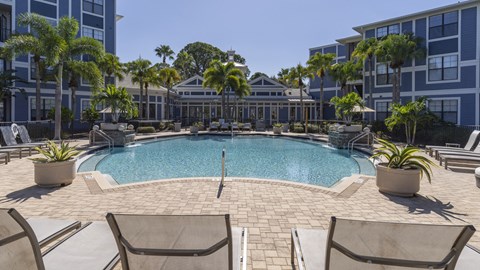 a large swimming pool in front of an apartment building