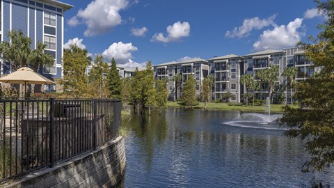 a pond with a fountain in front of a building