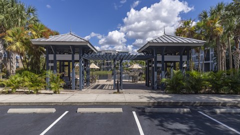 an empty parking lot with awnings and palm trees