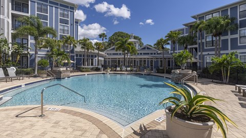 a swimming pool at an apartment building with palm trees