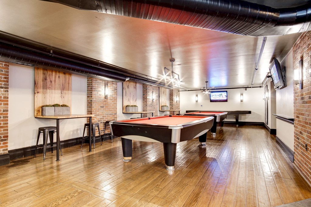a game room with two pool tables and a tv