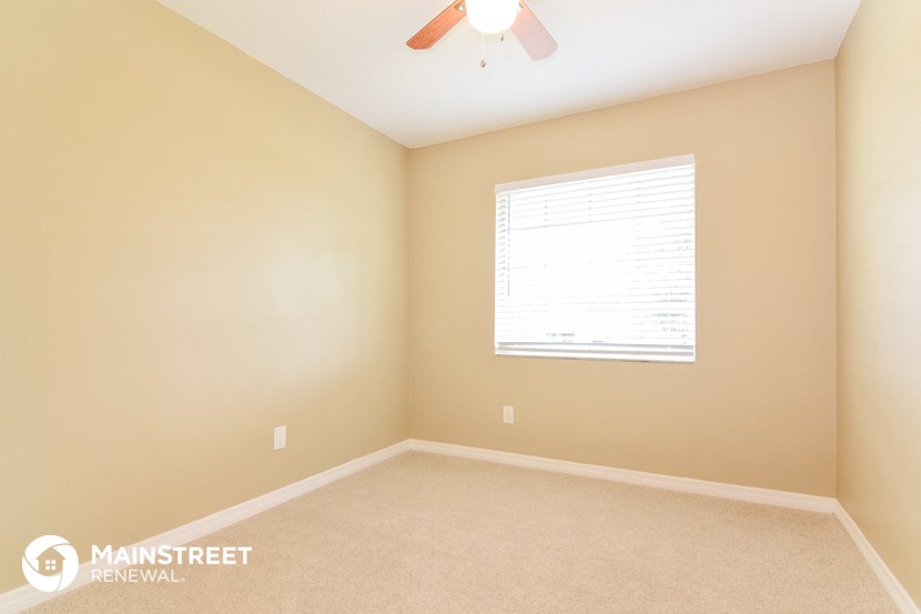 a bedroom with a ceiling fan and a window