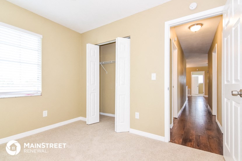 a hallway with two closets and a door to a bedroom and a hall way