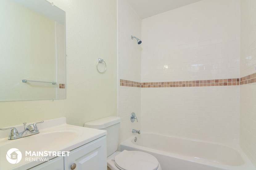 a white bathroom with a tub sink and toilet
