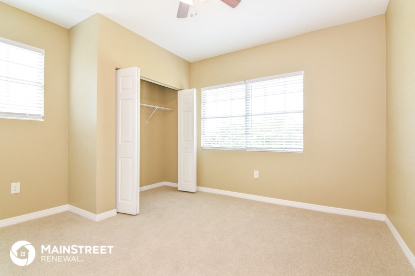 an empty room with a closet and a window and a door