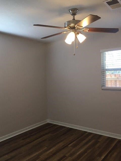 an empty room with a ceiling fan and a window