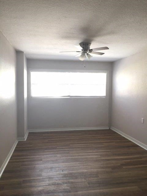 an empty room with a ceiling fan and a window